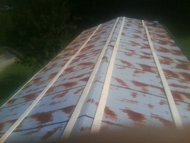 Rusted metal roof panels with new wood purlins before replacement — Storm Damage Roof Repair in Burbank by Roofing Brothers